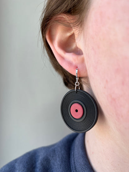 woman wearing a vinyl record earring with a red label